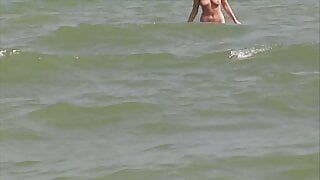 Une blonde allemande sexy se caresse la chatte humide sur la plage