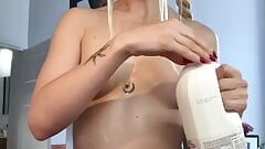 Linda gatita bebe leche de un tazón absolutamente desnuda