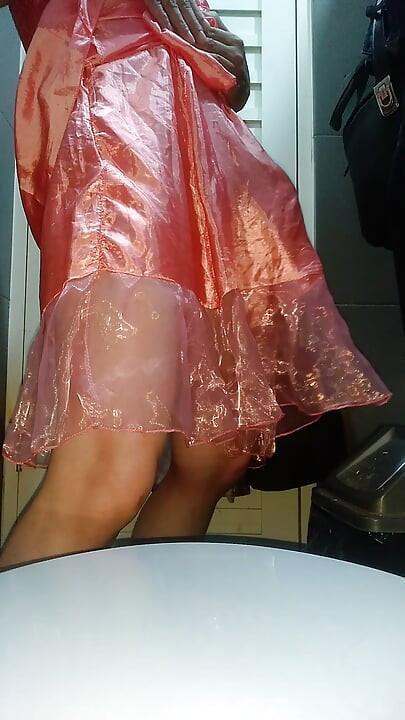 穿着可爱粉色缎面派对迷你裙的伪娘，身上还沾满精液