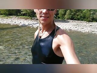 Schwimmen in mountain river in kleidung - turnschuhe, shorts und t-shirt