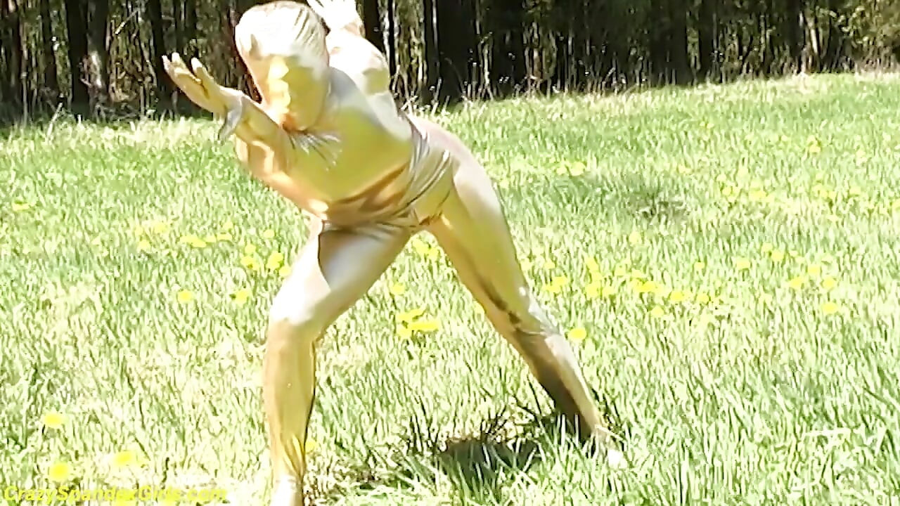 สาวผิวดําเซ็กซี่ในชุดสูทผ้าสแปนเด็กซ์สีทองผอมโพสท่าเอาท์ดอร์