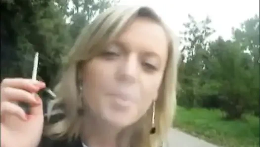 Sarışın güzel kadın açık havada sigara içiyor