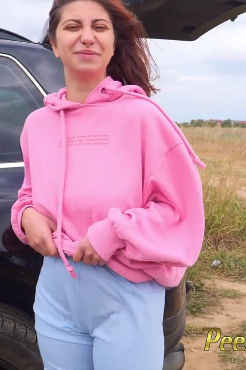 Hipster girl pee next to the wheel of the car