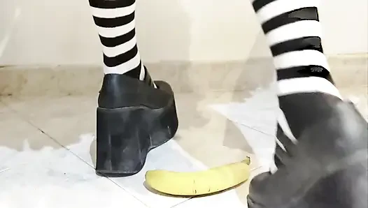 Goth crushing a banana under her shoes