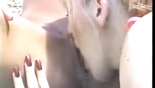 Sexy gebräuntes blondes duo fickt am strand mit einem strap-on