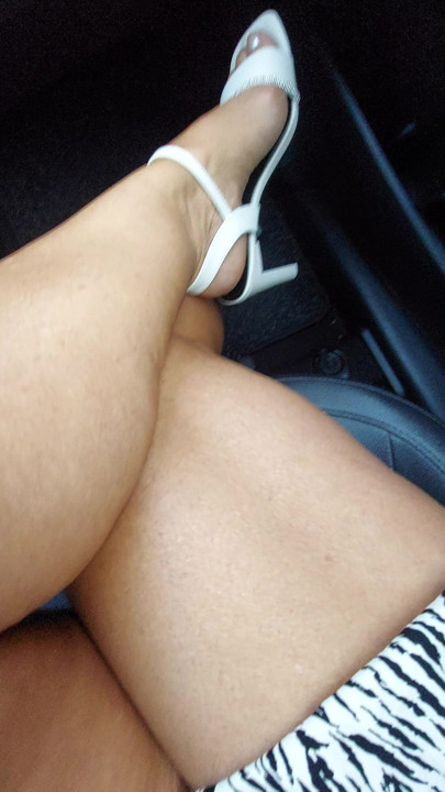 Mulher madura elegante em saia curta e salto alto no carro
