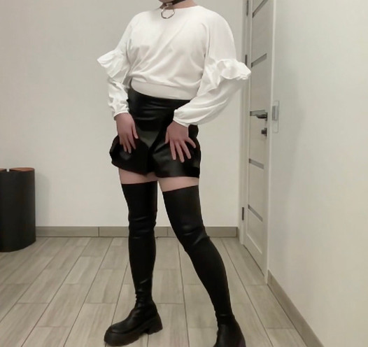 Sissy bdsm in leren korte broek, rok en witte kantoorblouse