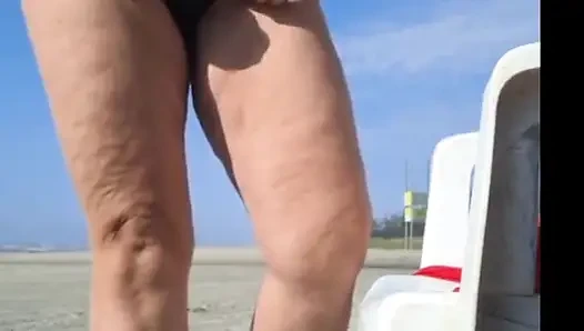Hot crown sunbathing on the beach in transparent micro bikini