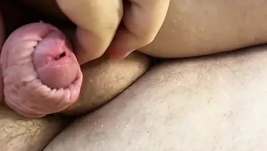 Kanepeye yatan şişman adam elsiz kalçasını gösteriyor ve boşalıyor, bolca sperm, sperm, sünnetsiz penis