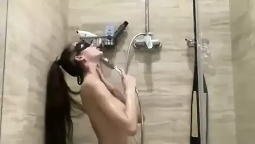 Brunetka z dużym biustem myje się pod prysznicem
