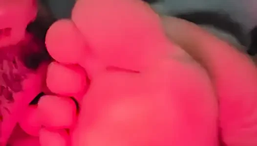 Sucking her toes while she watches a movie