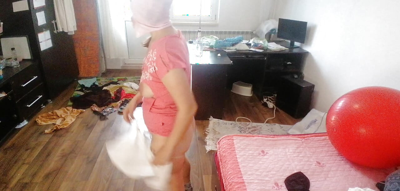 Amateur woman has fun trying on clothes and cutting them.