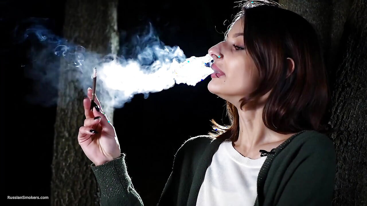 Édes orosz lány cigarettázik a szabadban nappali fényben