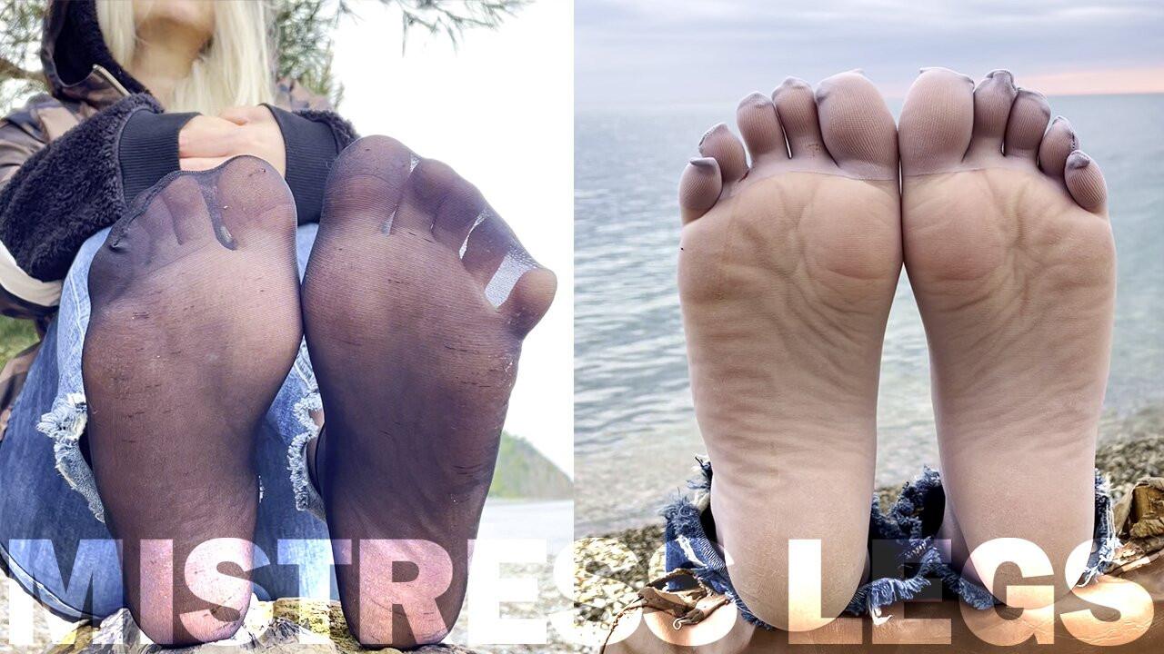 Pieds dans des chaussettes en nylon noires et grises, orteils qui remuent au bord de la mer
