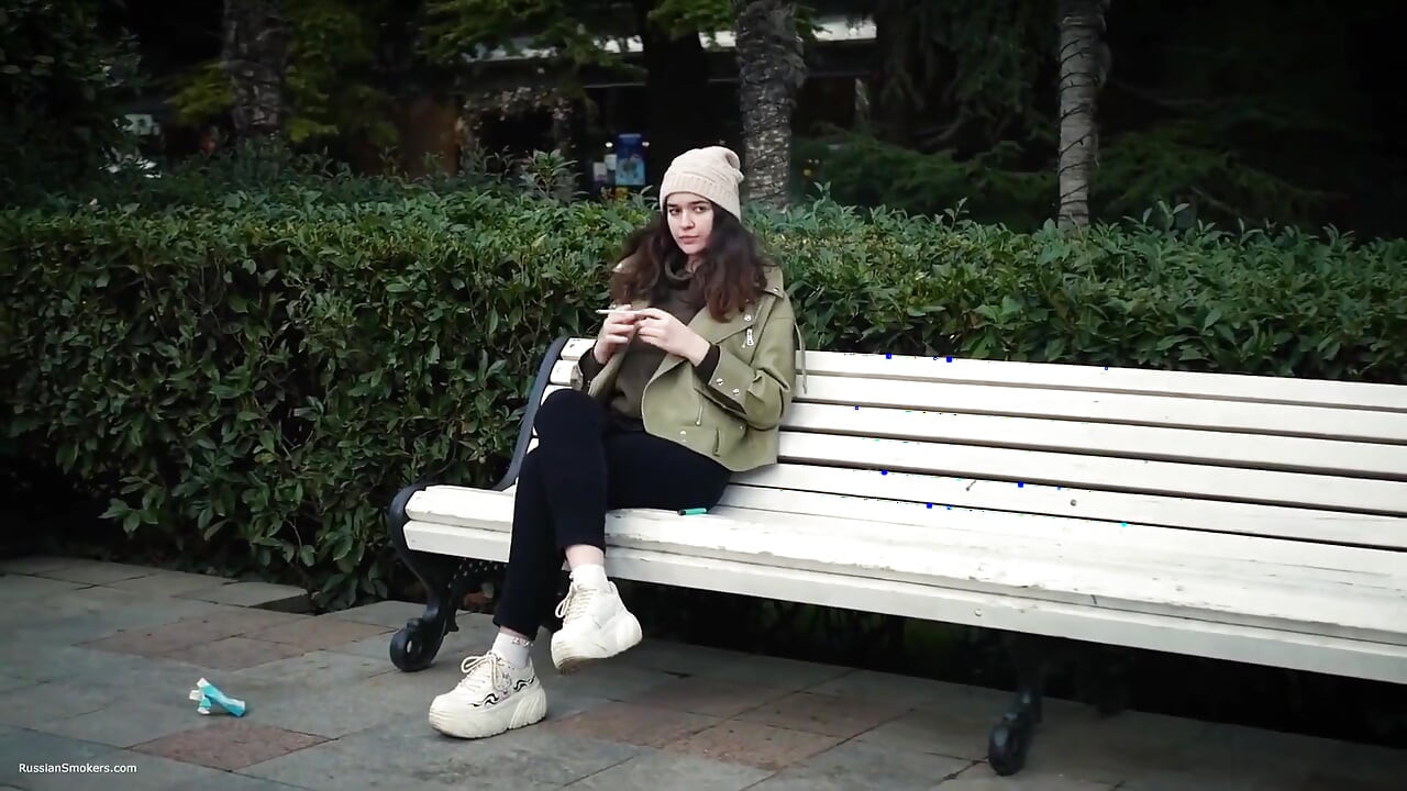 Young Brunette Is Taking an Unhurried Stroll with Allwhite 120mm Cigarette