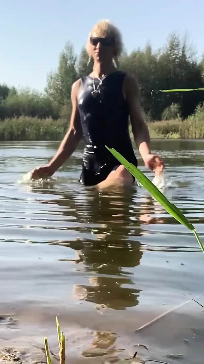 Trans girl swimming in the lake in blue sport dress. Wetllok trans girl wet.