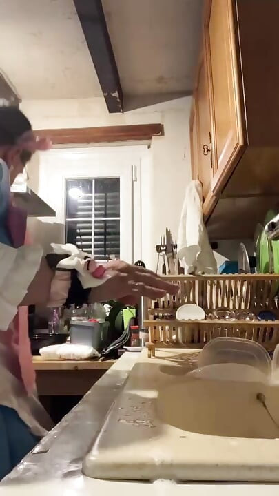 In a blue maid's outfit with pink bows to do the dishes.