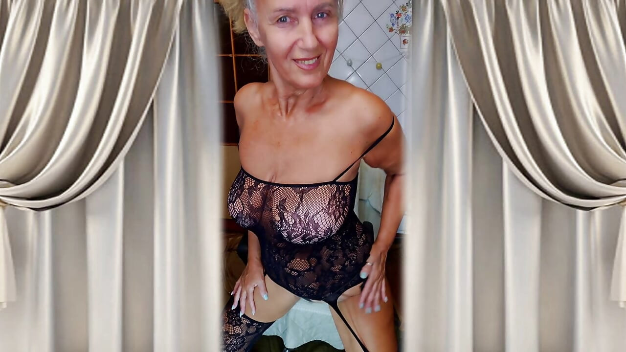 Hot housewife Lukerya flirts in a black fishnet dress at home in the kitchen.