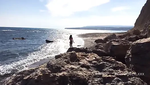 Yalnız gür Rus bebek deniz kıyısındaki kayada amını oyuncak yapıyor