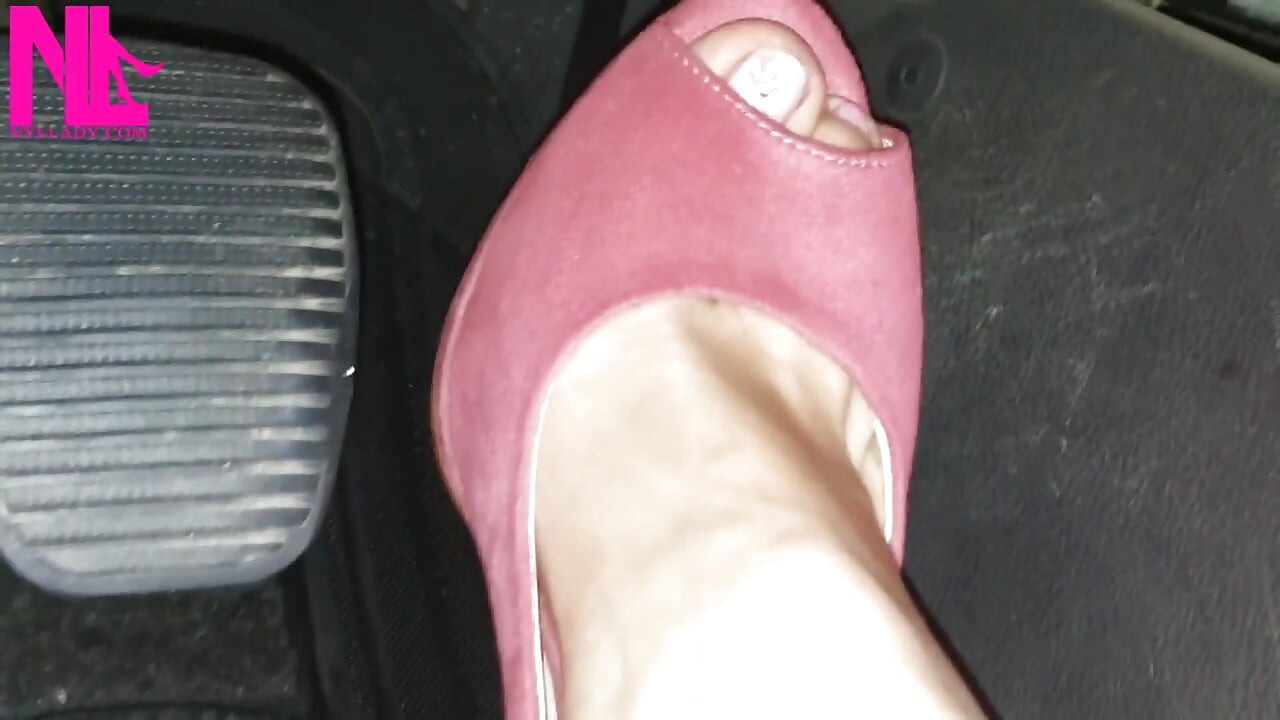 Rijden op blote voeten en in levendige roze sandalen met hoge hakken