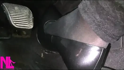Menyadarkan dan mengemudi dengan stoking hitam dan sepatu hak tinggi abu-abu