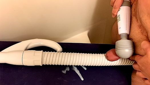 Handmassagevibrator die een kleine penis op een stofzuigerslang drukt en erop klaarkomt