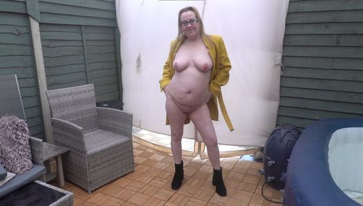 Une femme se déshabille complètement dans la cour dans le froid