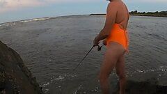 Baju renang one piece oranye di pantai