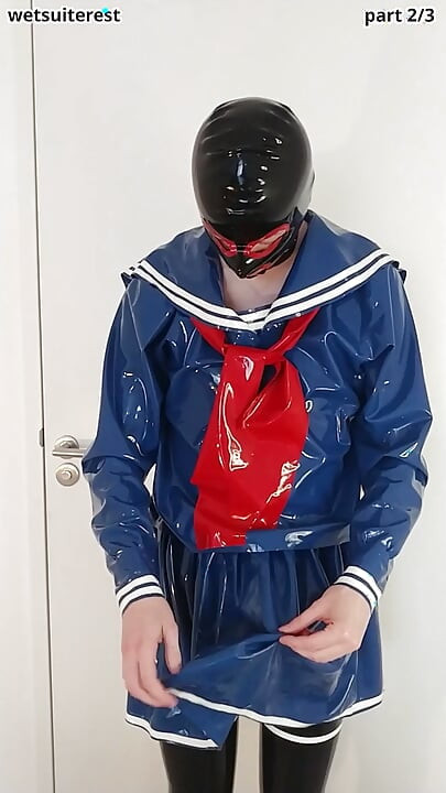 Poniéndose falda y camisa de uniforme de marinero de látex azul, medias de mucama de goma