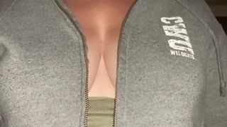 Abra o zíper da blusa mostrando os peitos