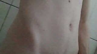 Jonge jongen masturbeert en toont zijn lichaam onder de douche
