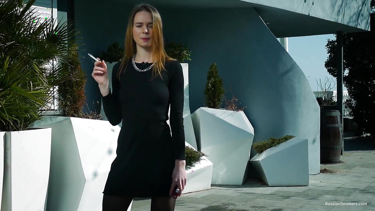 年轻的俄罗斯女孩在海边抽烟
