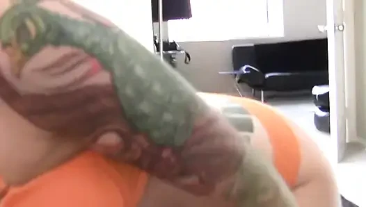 Brunette tattooed babe jerks cock between her ass