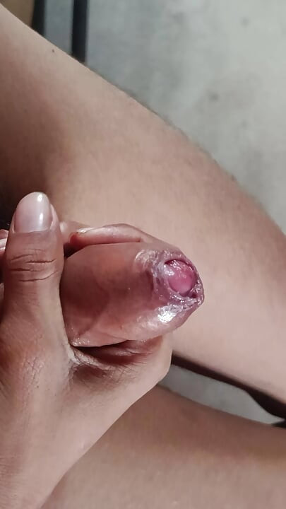 The boy is shaking his penis in his hand and ejaculating.