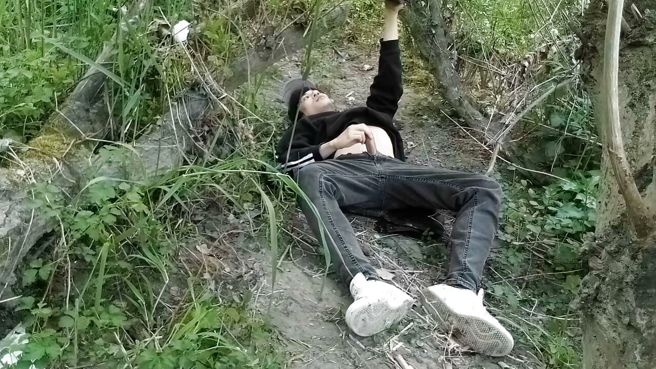 Dieser schwule twink steckt seinen schwanz durch seine fliege, um draußen zu wichsen