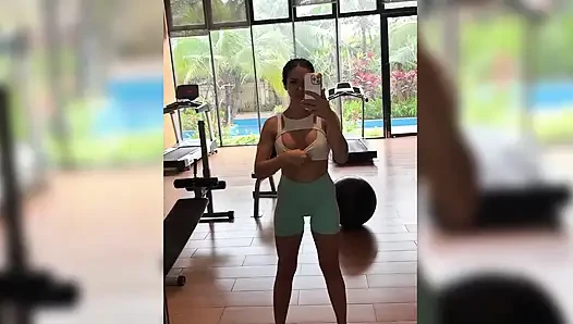 Seksi egzersiz, topun üstüne atlama, halka açık bir spor salonunda göğüslerini teşhir ediyor