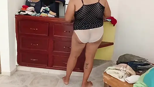 Tombul kız odayı topluyor ve kıyafetlerini katlıyor