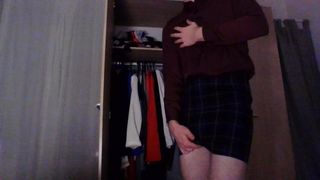 Transvestit in einem sexy Tartan-Sekretärin-Rock und Seidenhemd