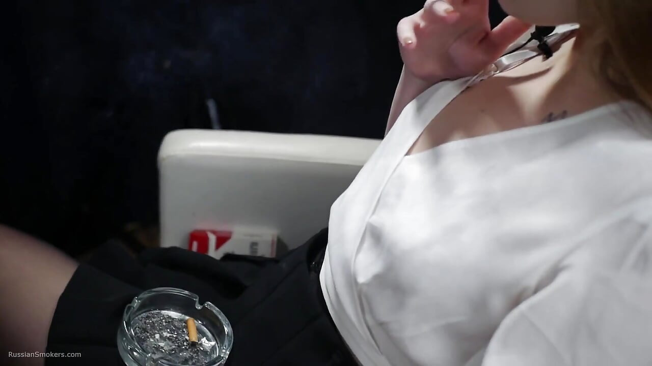俄羅斯金髮美女穿白色襯衫抽煙