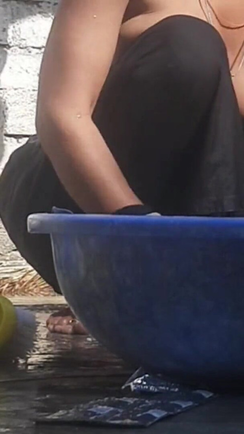 Indian stepsister is preparing to take a bath while washing clothes in the open courtyard of the house | Clip 1