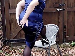 Hermosa travesti con curvas en sexy vestido de pelota de satén azul