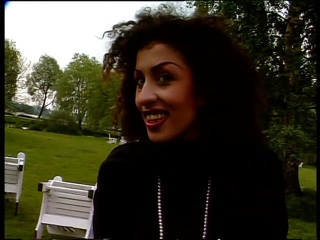 Une brune élégante donne une interview en plein air