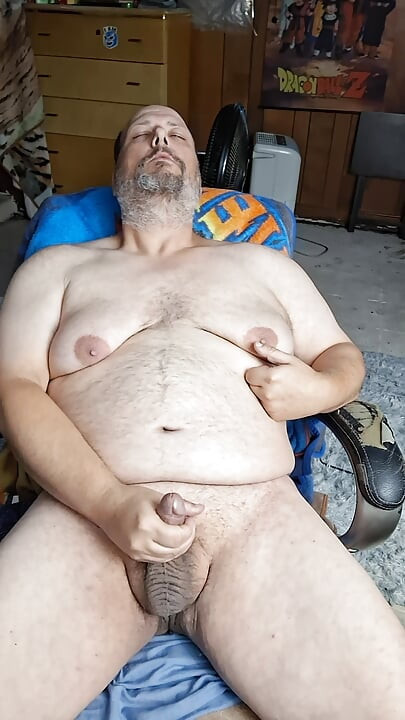 Chubby guy sits in chair and cums