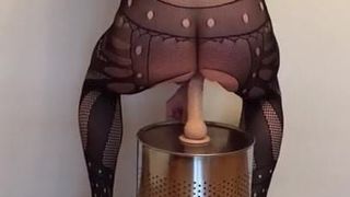 Blonde Blondine in Bodystocking und High Heels auf einem Dildo