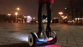 Hot girl driving gyroscooter in high heels and short skirt