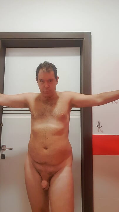 A boy completely naked in a station bathroom