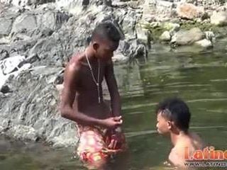 Tiener homo zwemmer die speels in de rivier afdaalt