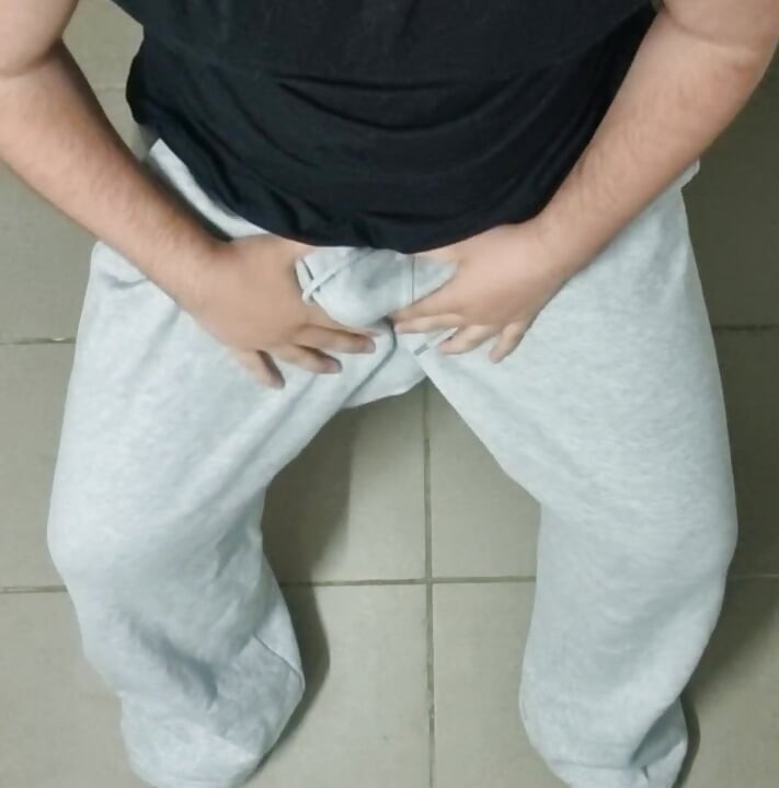 Wielki kutas jest w szarych spodniach dresowych