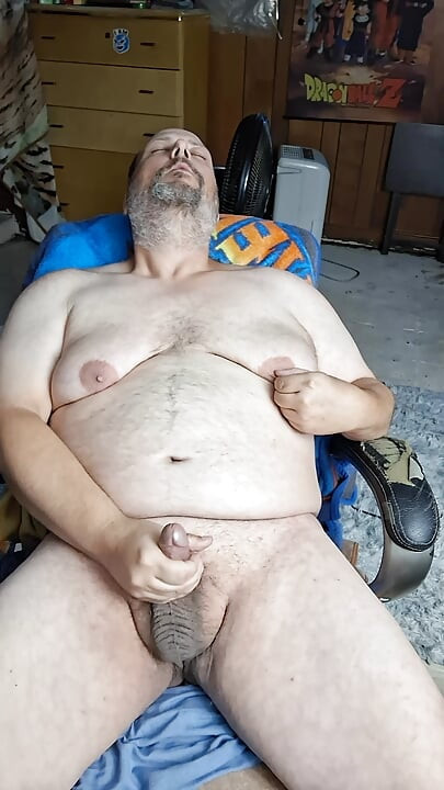 Chubby guy sits in chair and cums
