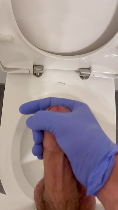 Doctor is jerking off with latex gloves at a toilet in Hospital